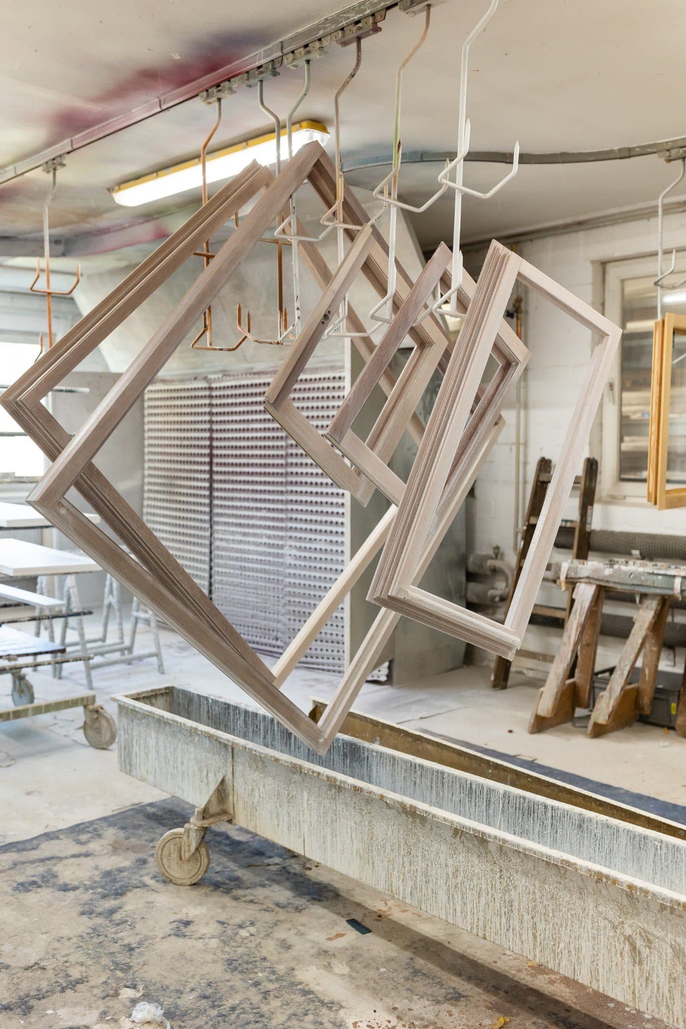 Frisch gefertigte Holzfensterrahmen hängen in der Oberflächenanlage der Klenke-Werkstatt in Detmold